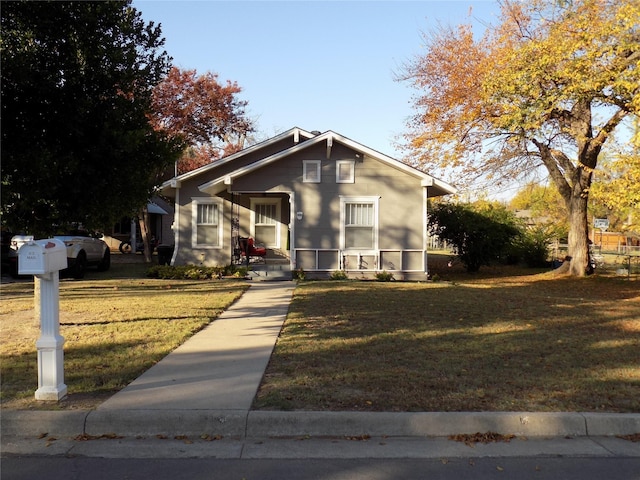 bungalow-style home featuring a front lawn