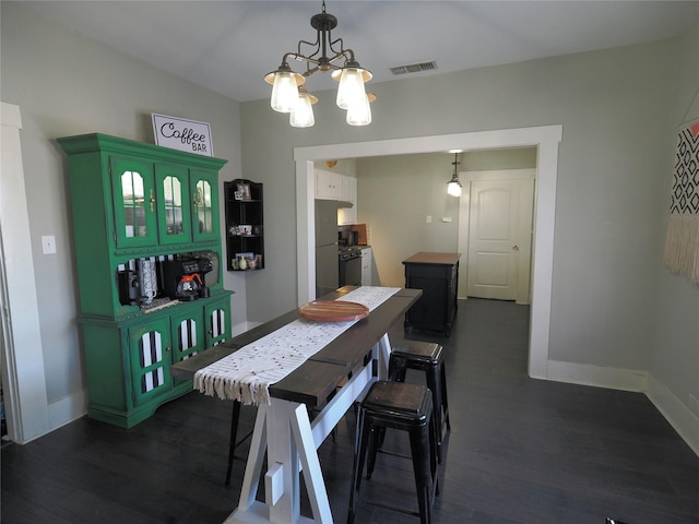 dining area with a chandelier and dark hardwood / wood-style floors