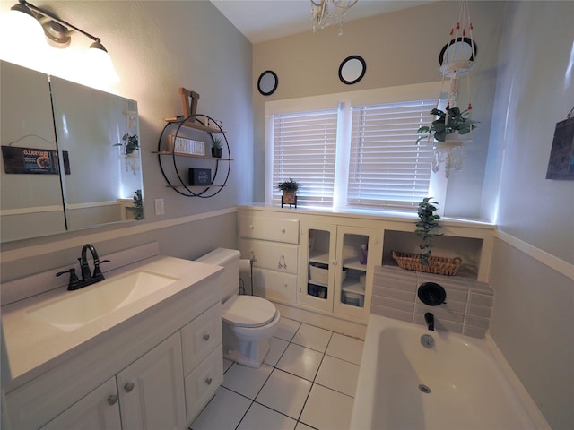 bathroom featuring a bath, vanity, tile patterned floors, and toilet