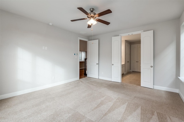 unfurnished bedroom with ceiling fan and light colored carpet