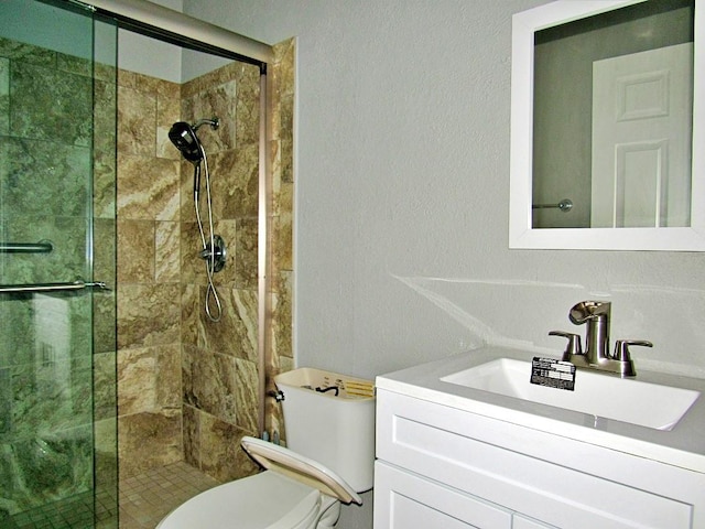 bathroom featuring toilet, walk in shower, and vanity