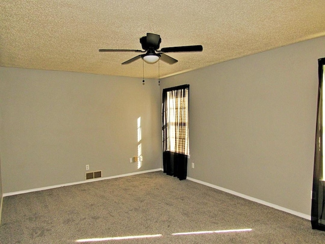 carpeted spare room with a textured ceiling and ceiling fan