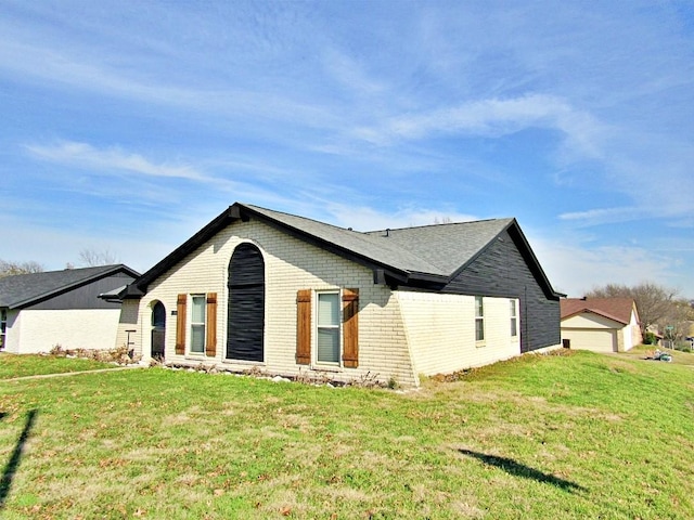 view of side of property with a yard and a garage