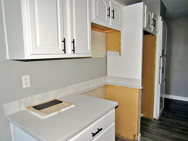 kitchen featuring dark hardwood / wood-style flooring and white cabinetry