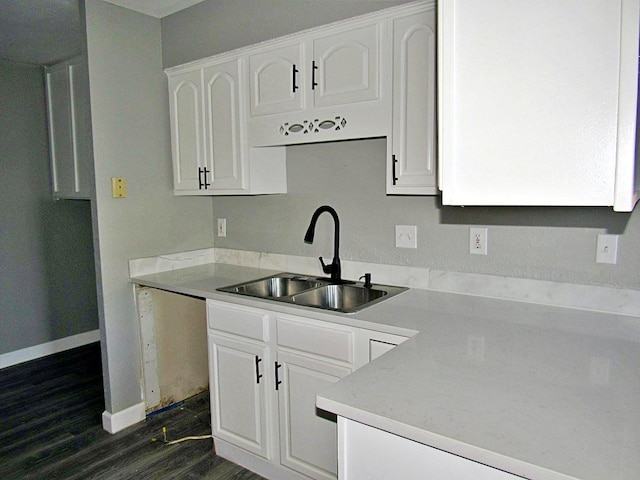 kitchen featuring white cabinetry, dark hardwood / wood-style floors, dishwashing machine, and sink