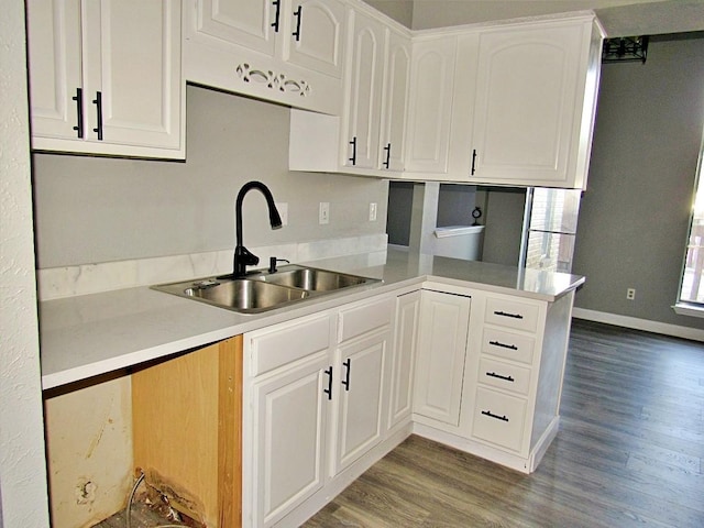 kitchen featuring white cabinets, kitchen peninsula, hardwood / wood-style floors, and sink