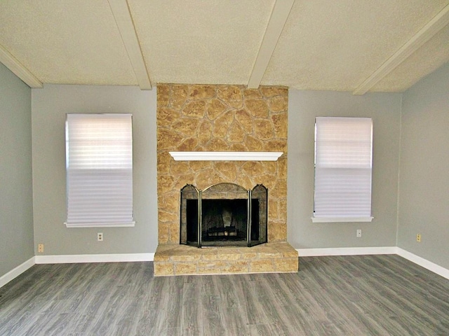 unfurnished living room with hardwood / wood-style floors, beamed ceiling, and a fireplace