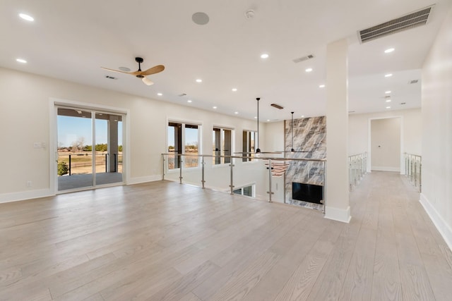 unfurnished living room with ceiling fan and light hardwood / wood-style flooring