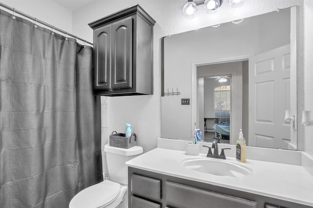 bathroom with a shower with shower curtain, vanity, and toilet