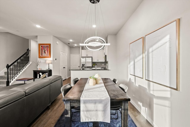 dining area featuring dark wood-type flooring and a chandelier