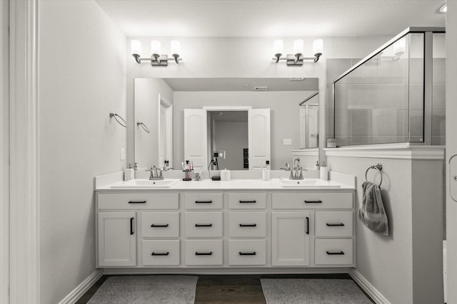 bathroom featuring hardwood / wood-style flooring, walk in shower, and vanity