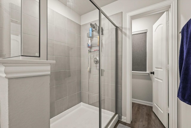 bathroom featuring a shower with shower door and hardwood / wood-style floors