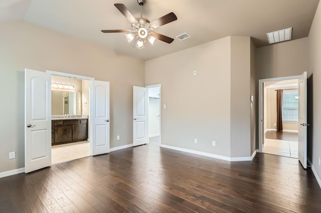 unfurnished bedroom with ensuite bath, ceiling fan, and dark hardwood / wood-style floors