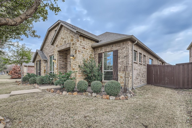 view of side of home with a yard