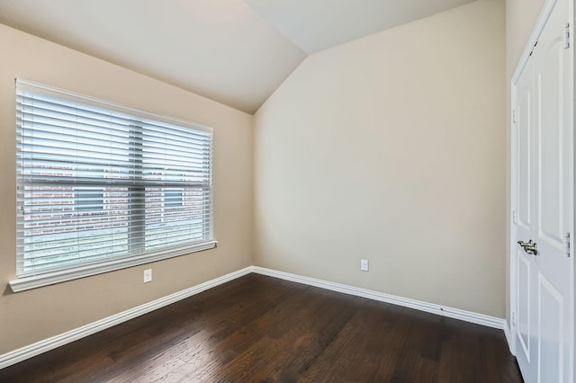 empty room featuring lofted ceiling and dark hardwood / wood-style floors