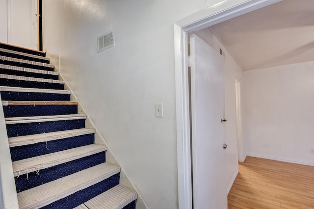 stairs featuring hardwood / wood-style floors