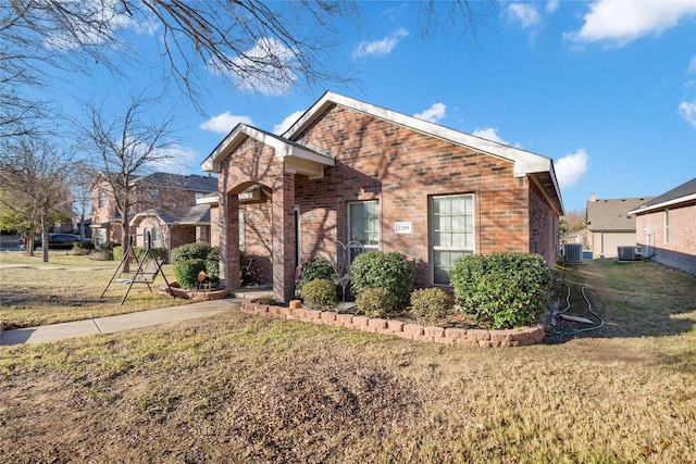 view of front property with central AC unit and a front yard