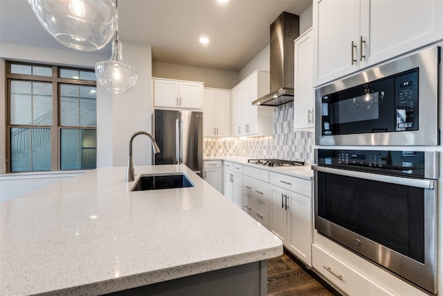 kitchen with light stone countertops, wall chimney exhaust hood, pendant lighting, stainless steel appliances, and white cabinetry