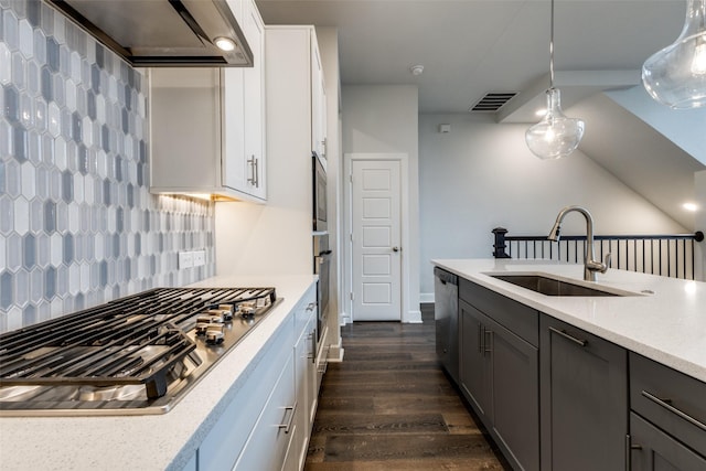 kitchen featuring custom exhaust hood, decorative light fixtures, tasteful backsplash, white cabinetry, and sink