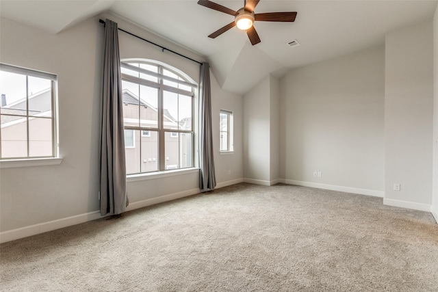 carpeted spare room featuring ceiling fan and vaulted ceiling