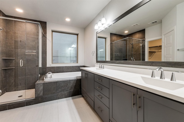 bathroom with vanity and independent shower and bath