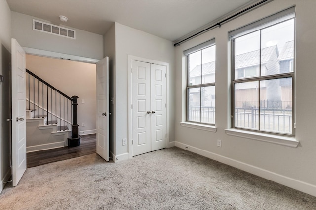 unfurnished bedroom with a closet and carpet floors