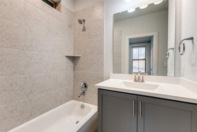 bathroom featuring tiled shower / bath and vanity