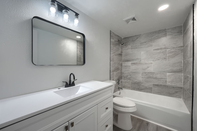 full bathroom featuring visible vents, toilet, tub / shower combination, vanity, and wood finished floors