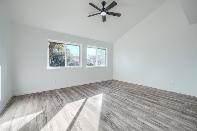 empty room featuring baseboards, a ceiling fan, vaulted ceiling, and wood finished floors