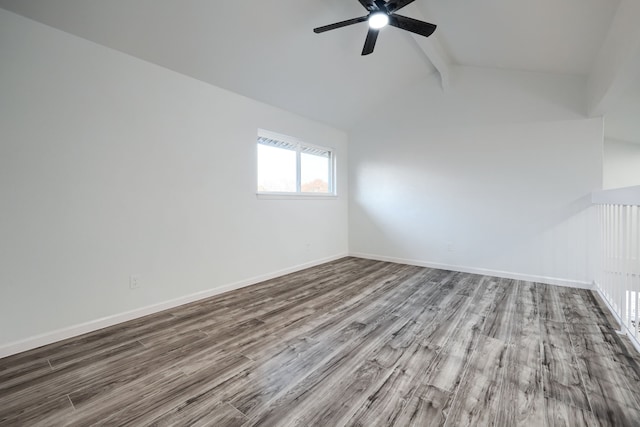 spare room with ceiling fan, lofted ceiling with beams, baseboards, and wood finished floors