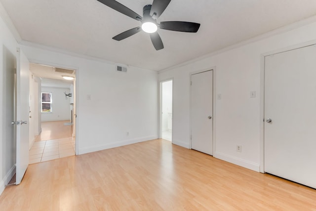 unfurnished bedroom featuring crown molding, ensuite bathroom, ceiling fan, and light hardwood / wood-style floors