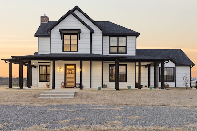 modern farmhouse with a shingled roof