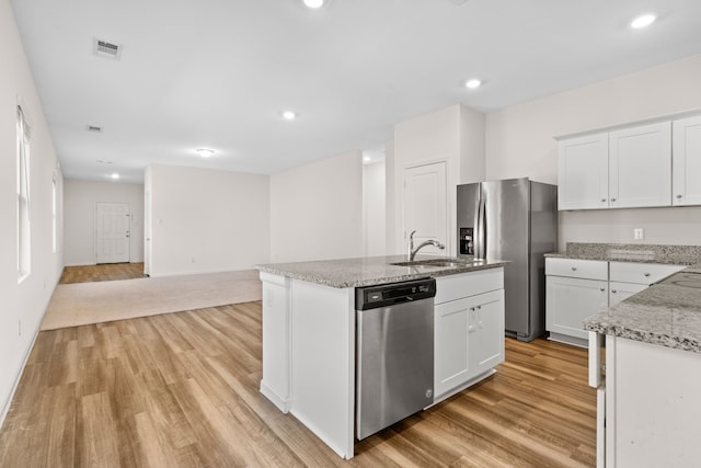 kitchen with stainless steel appliances, sink, white cabinetry, light hardwood / wood-style floors, and a kitchen island with sink