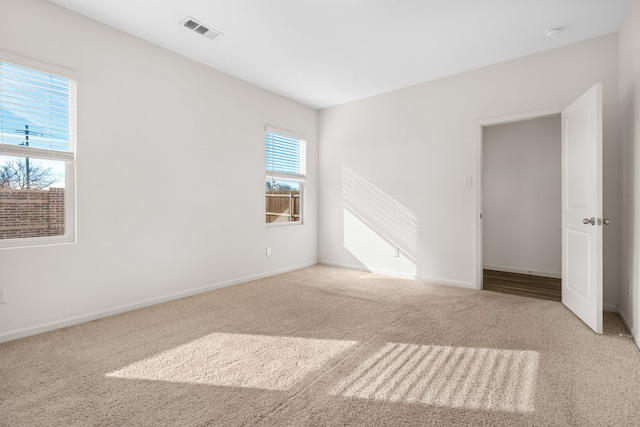 carpeted empty room with a healthy amount of sunlight