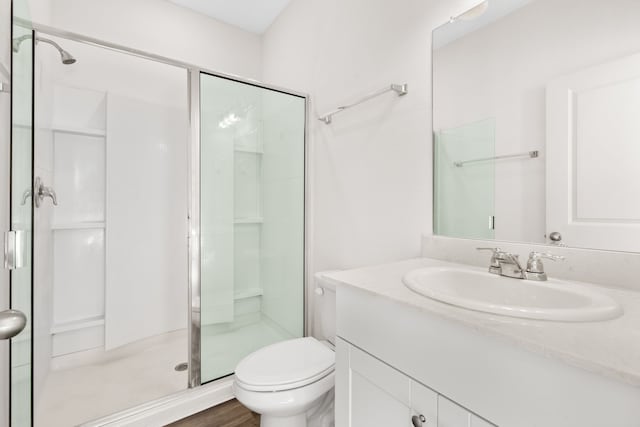 bathroom featuring toilet, walk in shower, vanity, and hardwood / wood-style floors