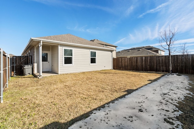 rear view of property featuring a lawn