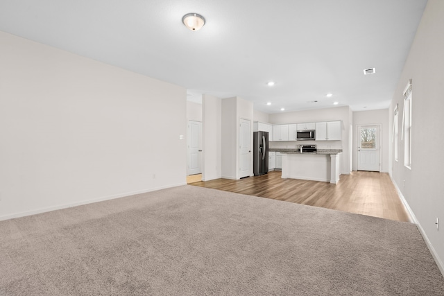 unfurnished living room featuring light colored carpet