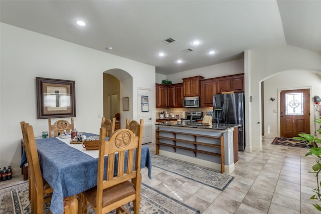 kitchen featuring stainless steel appliances, light tile patterned floors, and tasteful backsplash