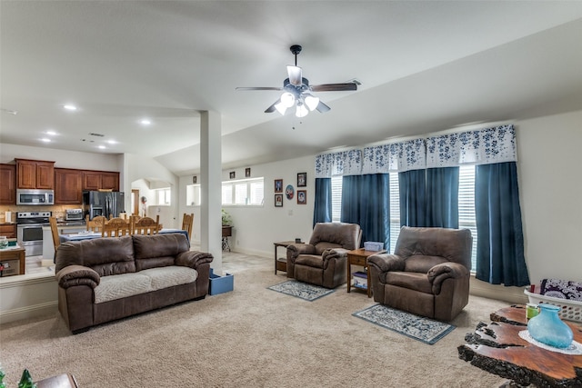 carpeted living room featuring ceiling fan, a wealth of natural light, and lofted ceiling