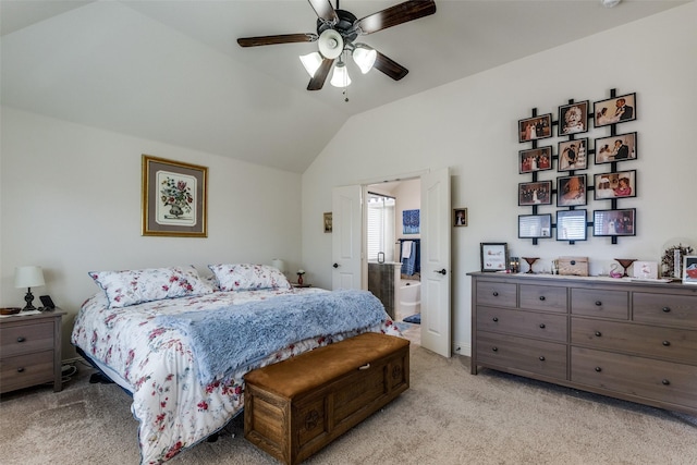 bedroom with vaulted ceiling, ensuite bathroom, light colored carpet, and ceiling fan