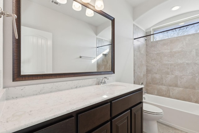 full bathroom with tiled shower / bath combo, vanity, and toilet