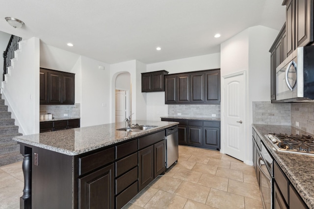 kitchen with sink, backsplash, a center island with sink, and stainless steel appliances