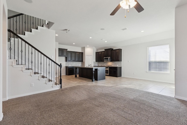 unfurnished living room with ceiling fan and light colored carpet