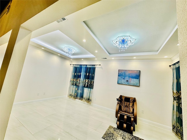 sitting room with a raised ceiling and crown molding