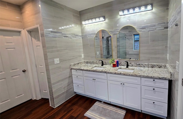 bathroom with tile walls, a shower, vanity, and wood-type flooring