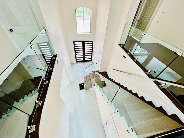 stairway featuring hardwood / wood-style floors and a towering ceiling