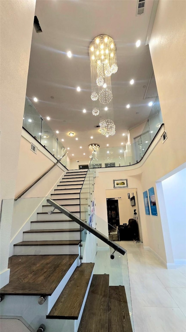 stairway featuring a high ceiling and an inviting chandelier