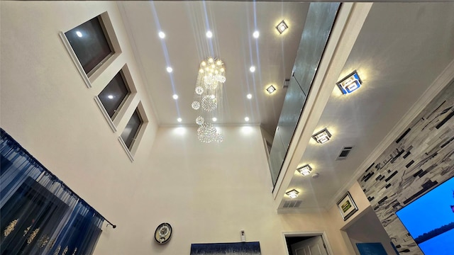 interior details featuring a notable chandelier and crown molding