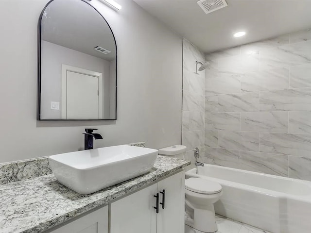 full bathroom with toilet, vanity, and tiled shower / bath