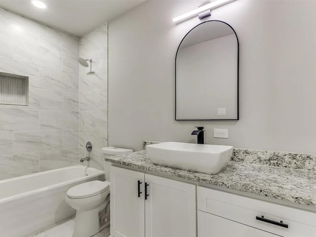 full bathroom featuring toilet, tiled shower / bath, and vanity